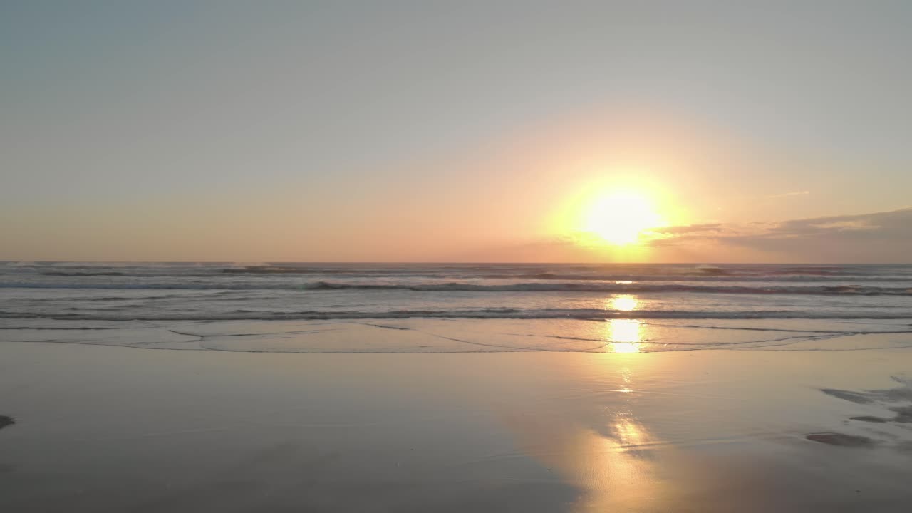 해질녘에 부드러운 모래 해변에서 바다를 향해 낮고 천천히 날아갑니다.