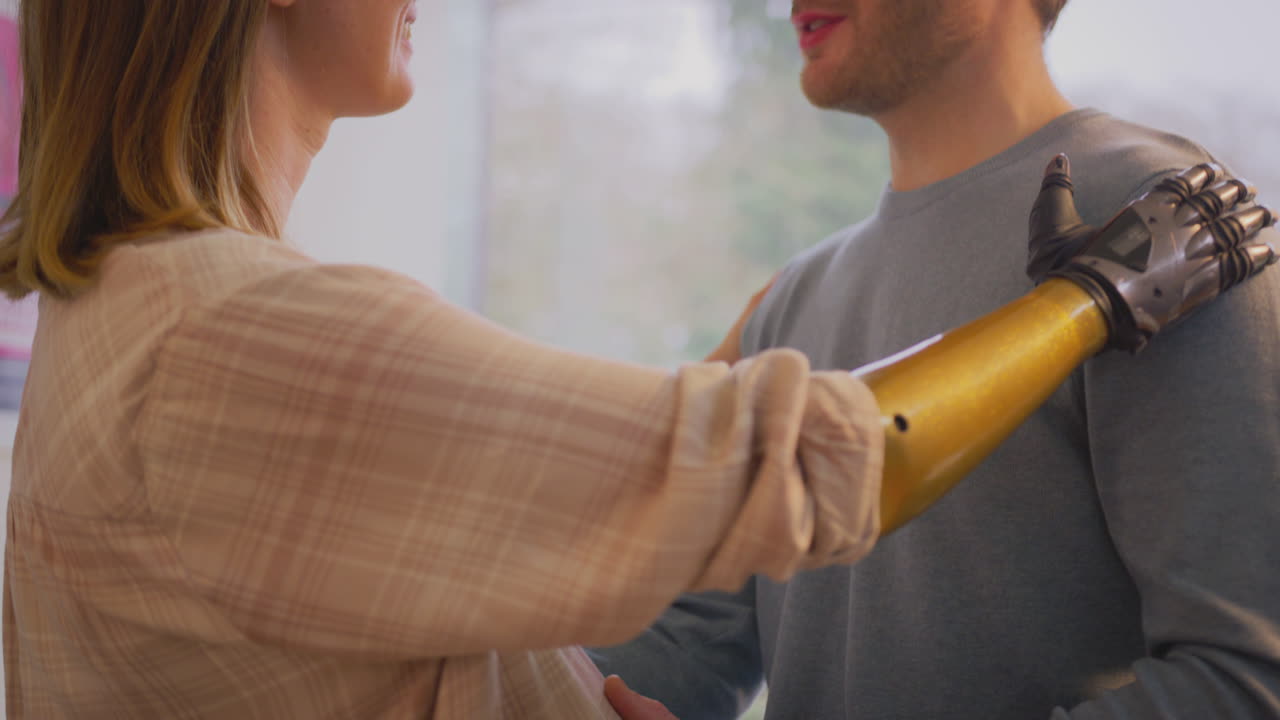 임신 한 부부 와 의수 팔 을 가진 여자 가 집 에서 함께 춤 을 추고 있다