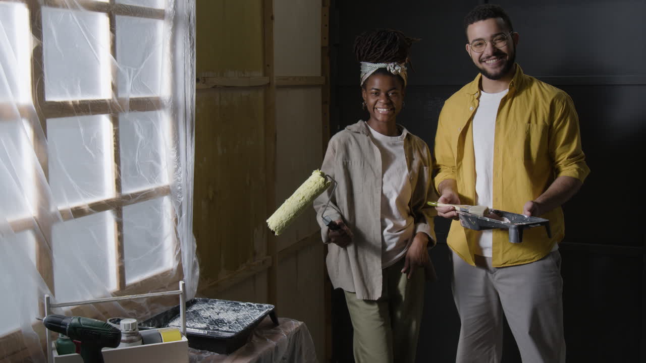una pareja pintando una habitación.