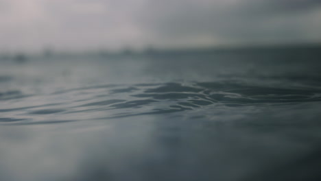 Mystic-dreamy-ocean-water-as-rain-droplets-splash-on-surface