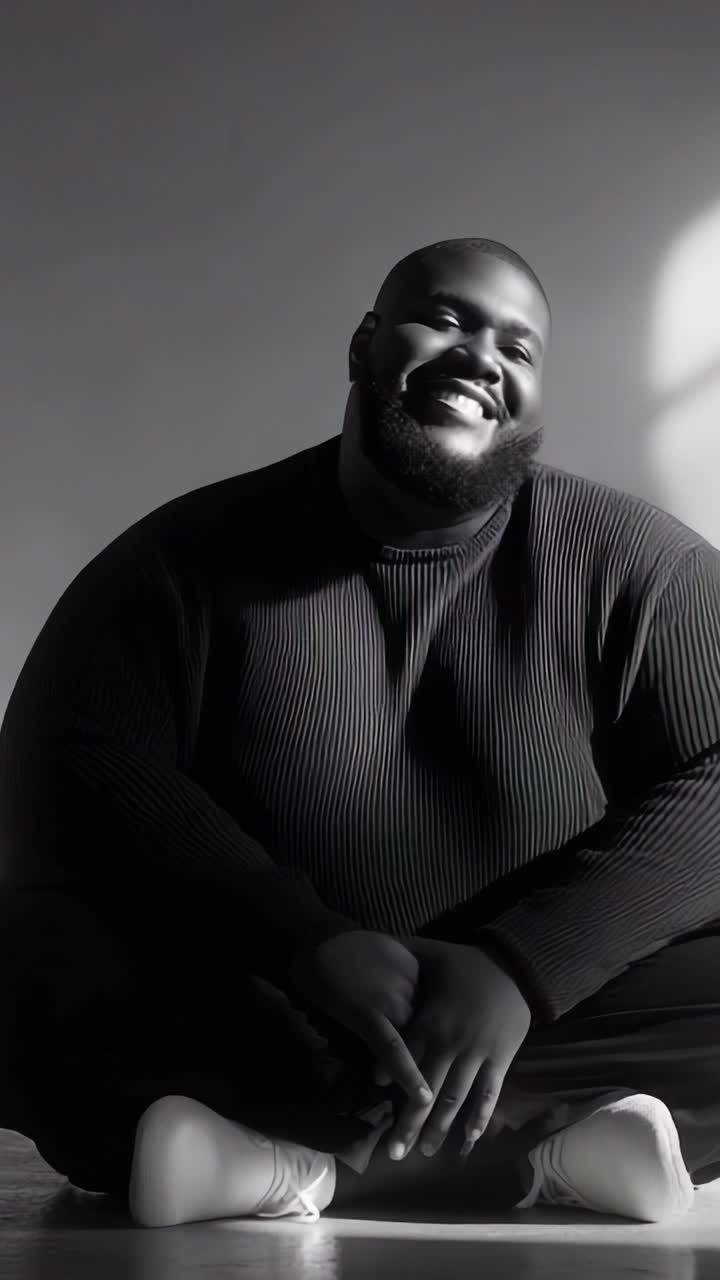 A joyful moment captured in a serene setting, showcasing a smiling individual in a black striped sweater, radiating positivity and charm with a playful demeanor