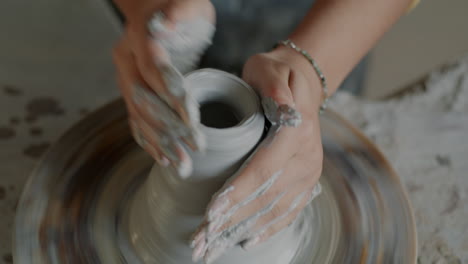 woman shaping pottery on a wheel