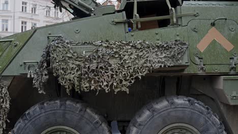 armored vehicle with camouflage in downtown riga, tilt up view