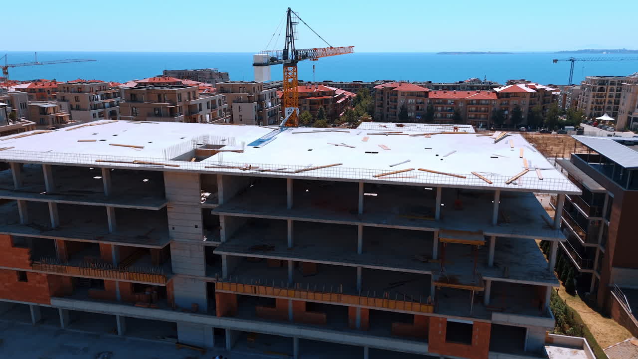 Varna, Bulgaria, 11 July 2025: Construction site overlooking the sea. Workers are busy at a seaside construction site, surrounded by buildings and cranes