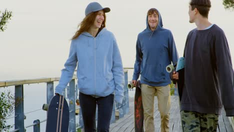 Front-view-of-young-caucasian-skateboarders-walking-with-skateboard-at-observation-point-4k