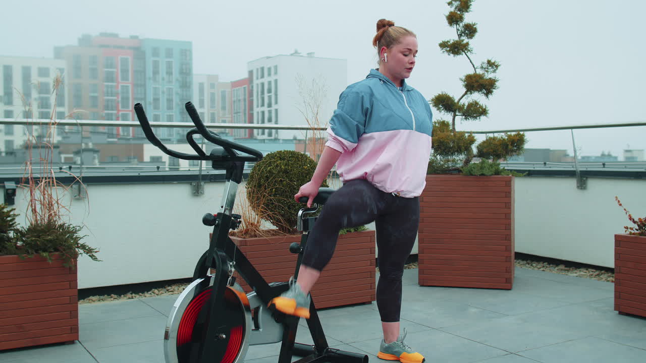 여성은 시 ⁇ 레이터, 사이클 트레이닝에서 유산소 지구력 훈련 운동 심장 루틴을 수행합니다.
