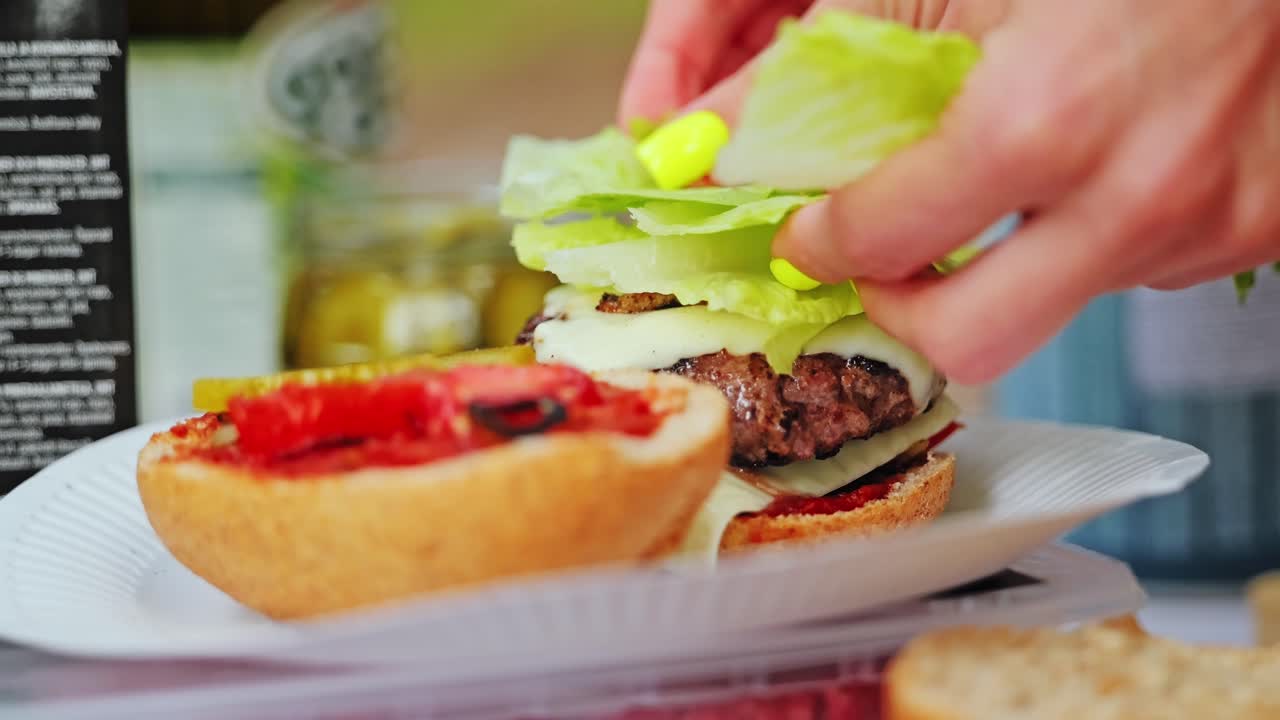 Burger is finished with crisp lettuce during peaceful nature camping moment