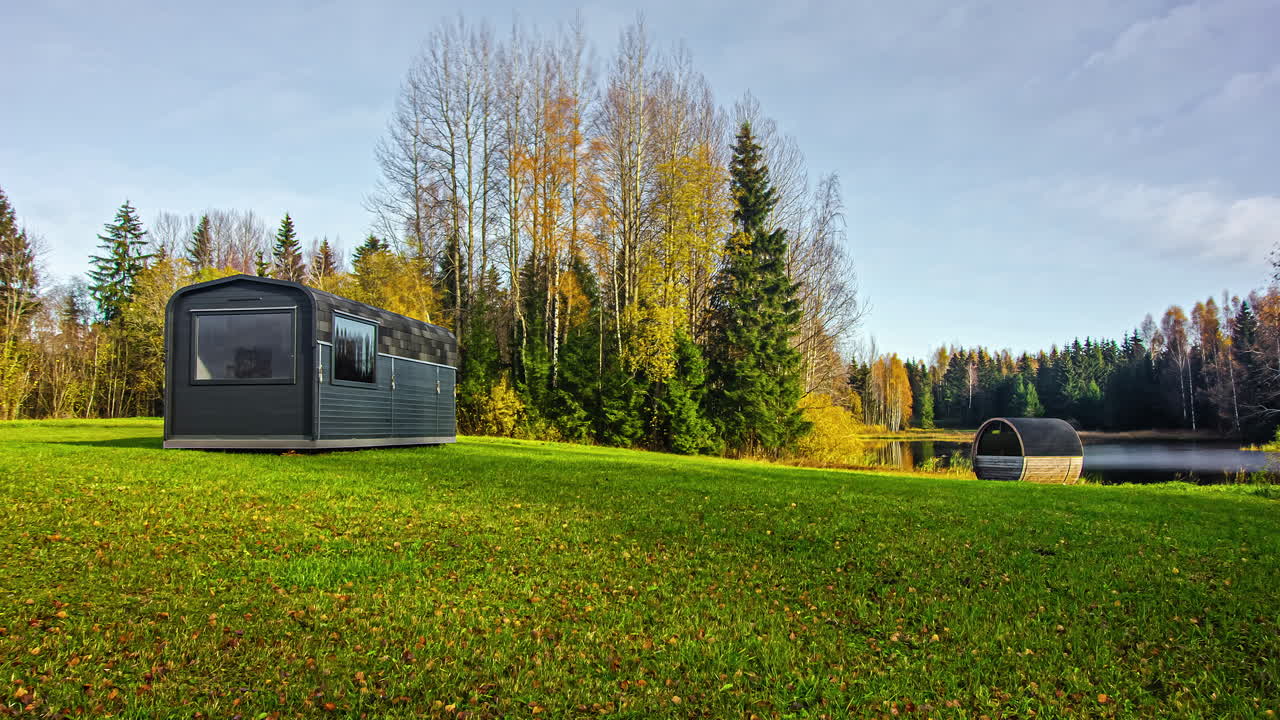구름이 햇빛을 차단할 때 그림자가 캠핑 트레일러와 함께 들판을 가로지릅니다 - 시간 경과