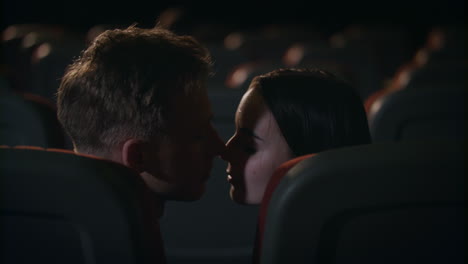 cinema couple in love. romantic date in movie theater. kissing couple