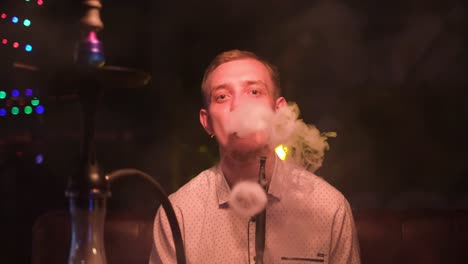 man smoking hookah in a bar