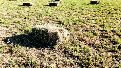 wonderful motion around large straw bale in middle of empty autumn field under pictorial sky