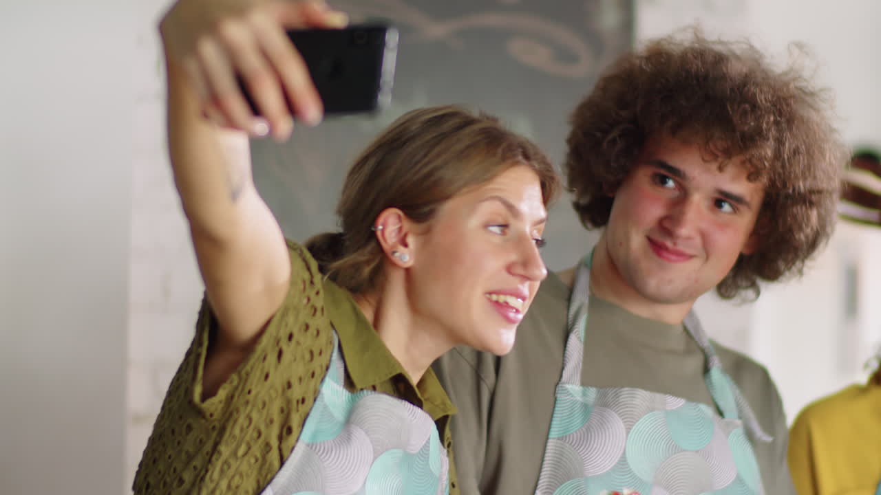 Amici multietnici e allegri che si fanno un selfie durante una masterclass di cucina