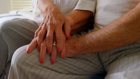 close-up of senior couple holding hands in bedroom at comfortable home 4k