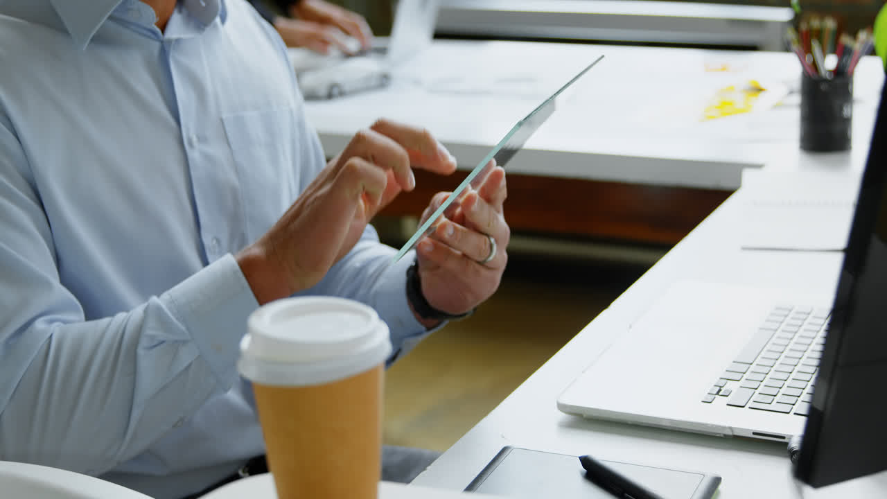 ejecutivo usando una tableta digital de vidrio en la oficina 4k