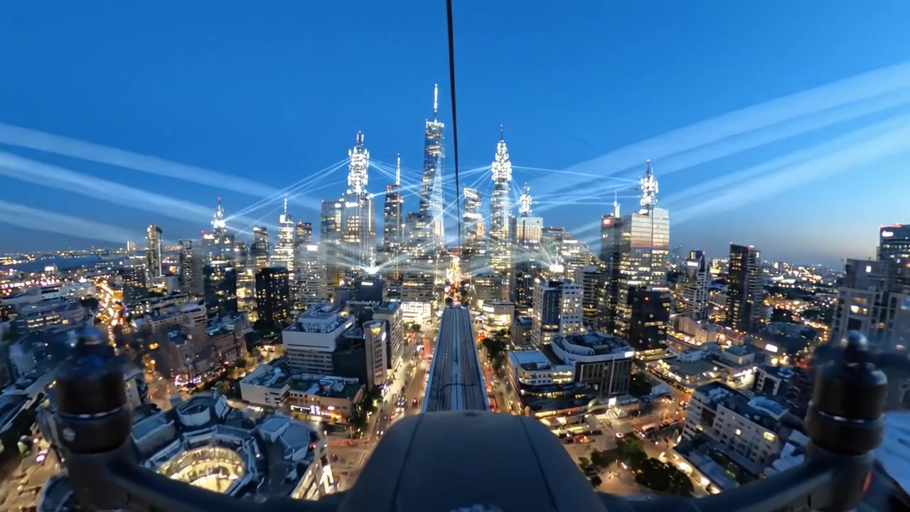 Vista aerea di grattacieli illuminati di notte con luci interconnesse e paesaggio urbano catturato dall'alto in un contesto di città moderna.