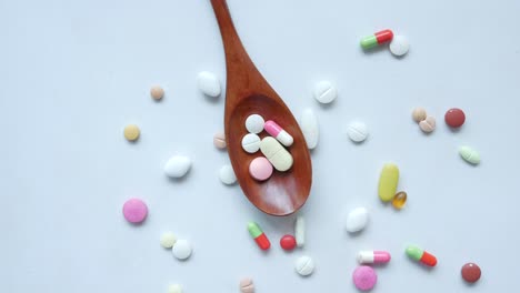 assorted pills on a wooden spoon