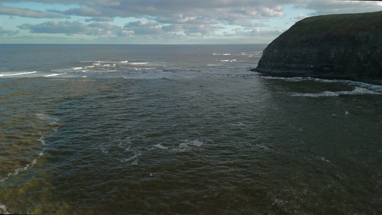 Plan d'établissement par drone s'éloignant vers la mer depuis Staithes, Yorkshire, Royaume-Uni
