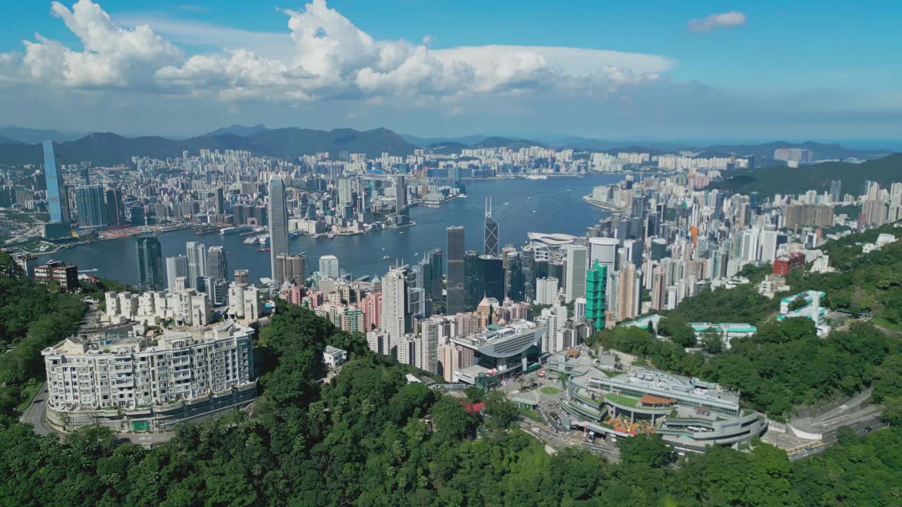 Aerial drone footage capturing Hong Kong harbour with city skyline, bustling vessels, and waterfront views, highlighting maritime transport, urban architecture, and iconic coastal landscapes