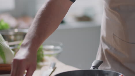 chef cocinando verduras en una sartén