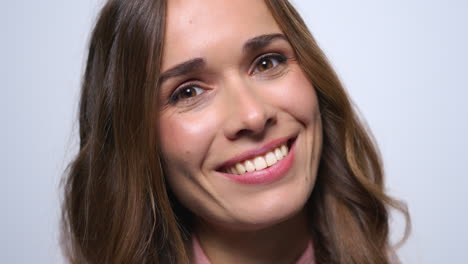 mujer hermosa coqueteando con la cámara. cara de mujer joven sonriendo en el estudio