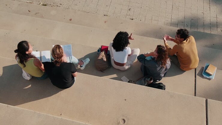 Happy guys and girls having fun talking outdoors. Top view