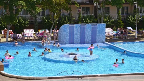 mensen die zich ontspannen in het zwembad. zomer buiten mensen in zwembroek zwemmen samen in zwembadwater