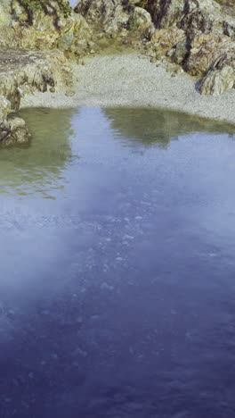 serene calm waters reflect rocky landscape under clear skies
