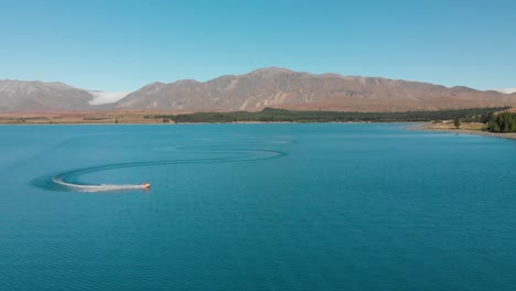 fastmo - jet ski on beautiful turquoise blue water - lake tekapo, new zealand - aerial