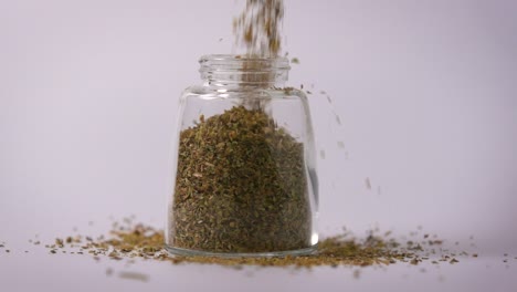 Slow-Motion-Close-Up-Oregano-Powder-Pouring-In-Jar