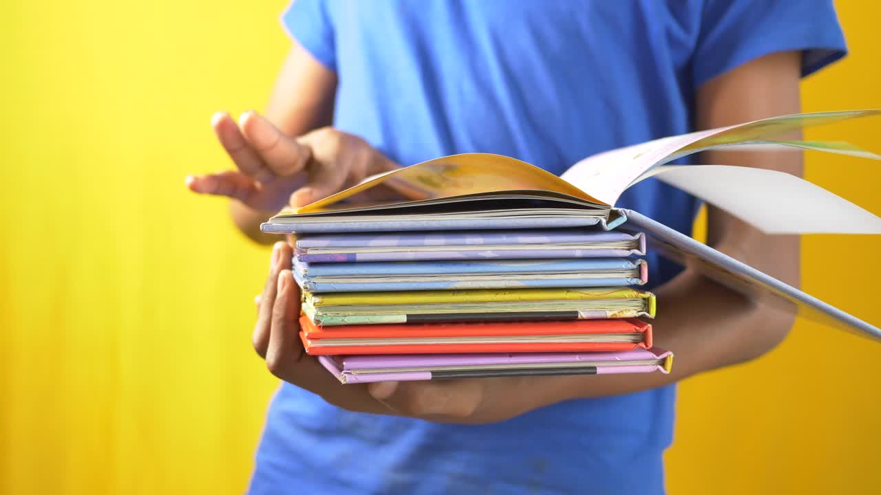 niño sosteniendo una pila de libros