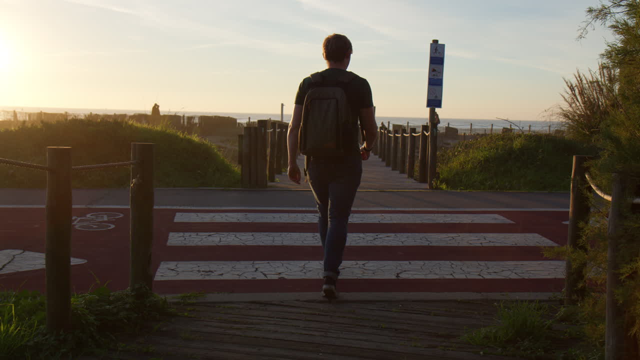 Man crossing a bike path to the beach in Vila Nova de Gaia, Portugal