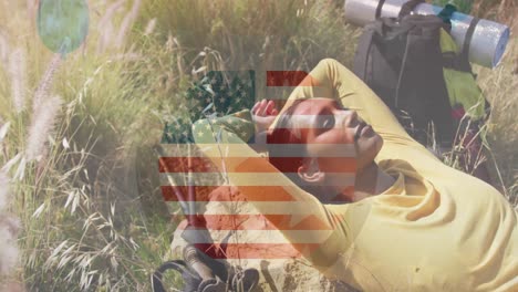 animation of american flag over biracial woman lying in mountains