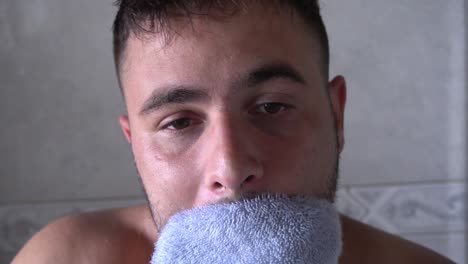 hombre secándose la cara después de la ducha