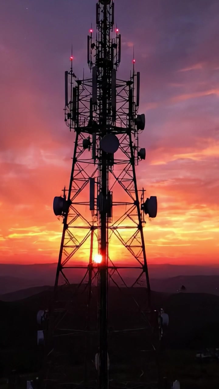 A Silhouetted Communication Tower Against a Stunning Sunset Sky, Highlighting Technological Infrastructure in Natural Beauty