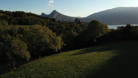 vista cinematográfica de un castillo europeo de ensueño rodeado de montañas y un lago