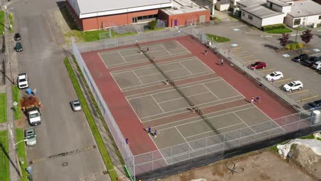 people playing tennis on an outdoor tennis court