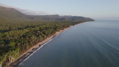 ocean waves splashing on the beach shore at wangetti beach from rex lookout, north queensland, australia - aerial drone shot