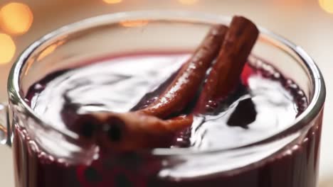 rich, dark beverage with cinnamon sticks captured in two frames, showcasing the glimmering surface and aroma of a cozy winter drink experience
