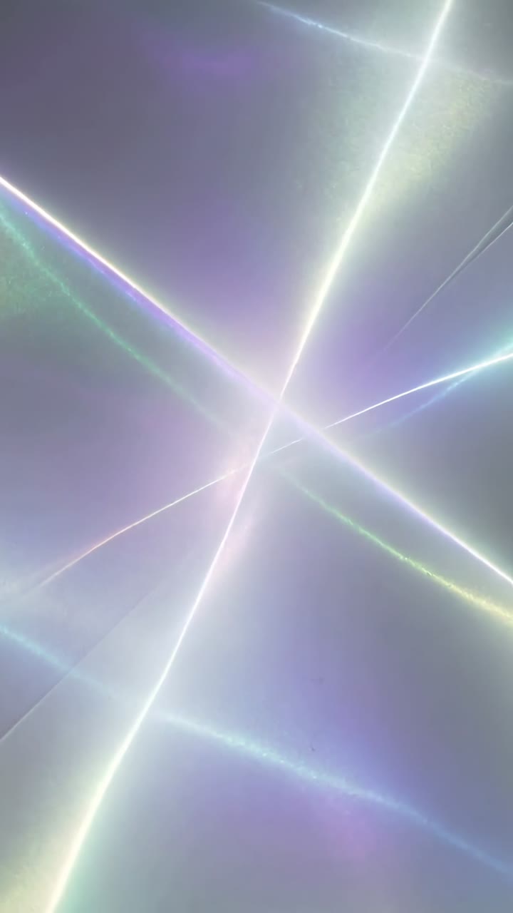 Video verticale: Fotogrammi che avanzano spingendo raggi di luce che ruotano verso l'interno, formando una stella pastello al centro.