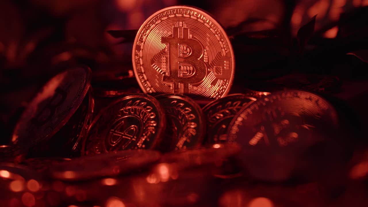 static shot of a group of golden bitcoins with blue light passing over