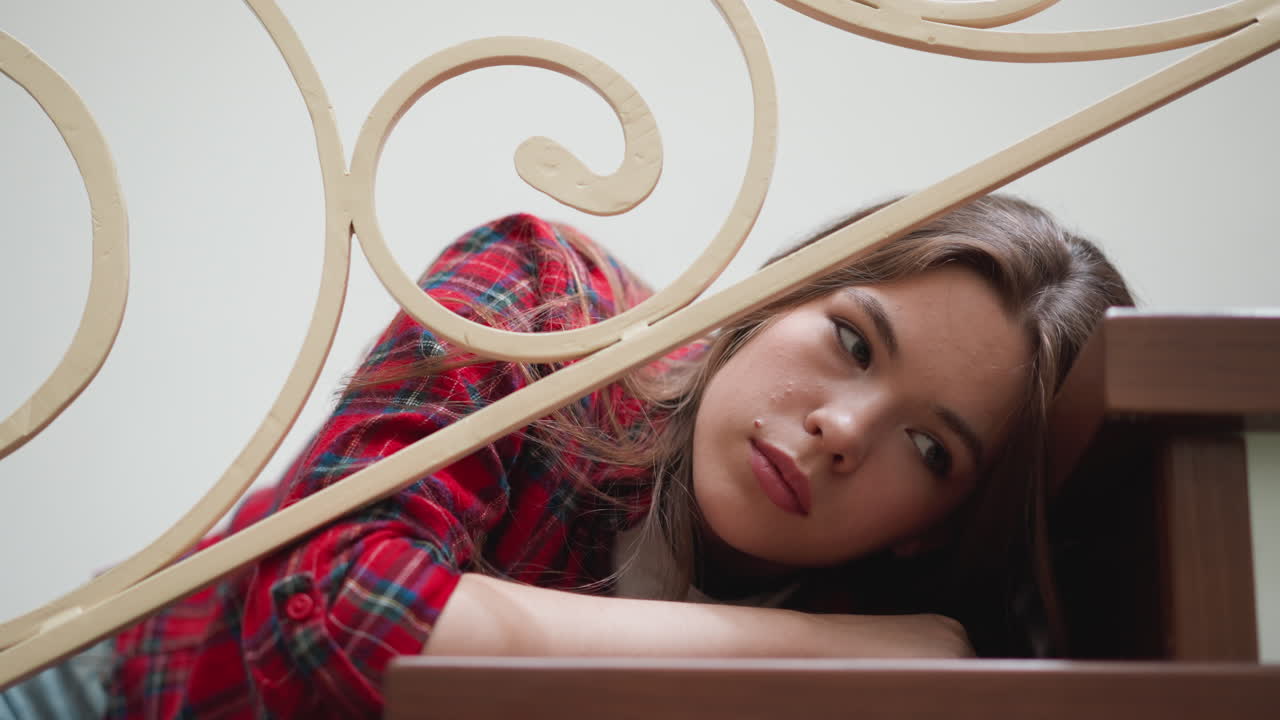 Mulher fragilizada com problemas de saúde mental deitada em uma escada em close-up. Uma mulher com expressão apática cede a um colapso emocional em casa. Transtorno depressivo.