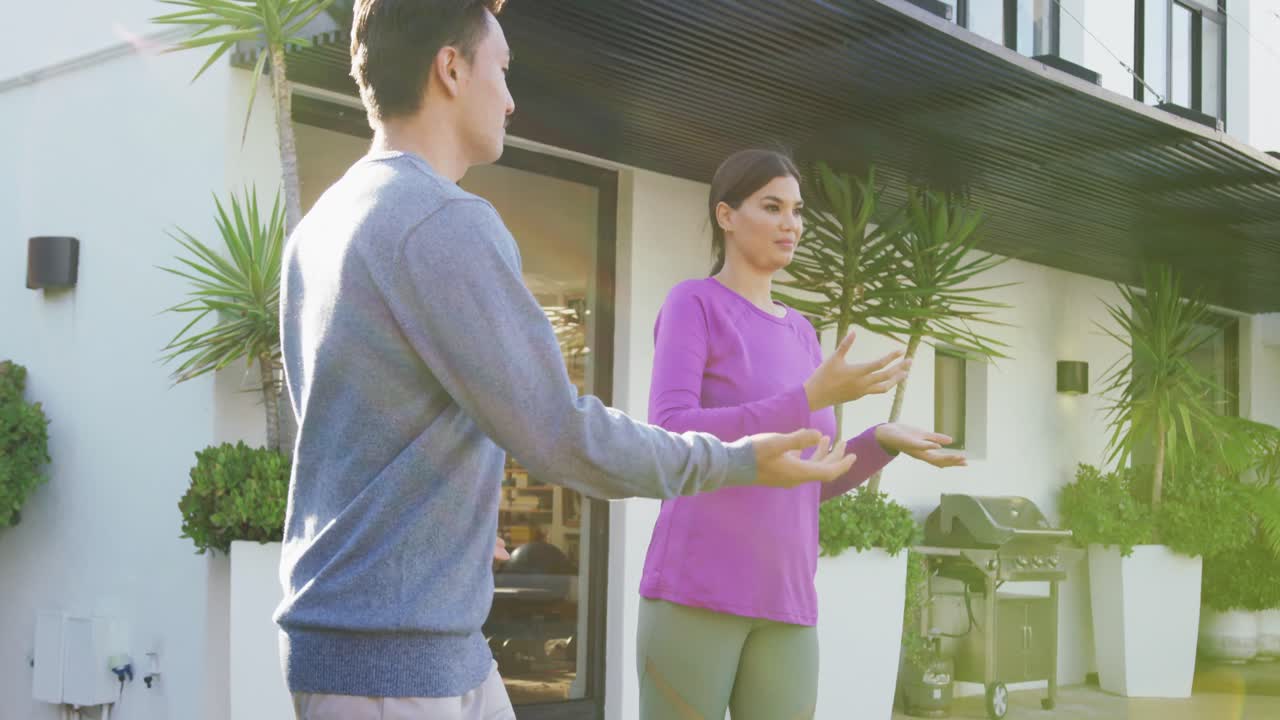 정원에서 태극기를 연습하는 편안한 다양한 커플의 비디오