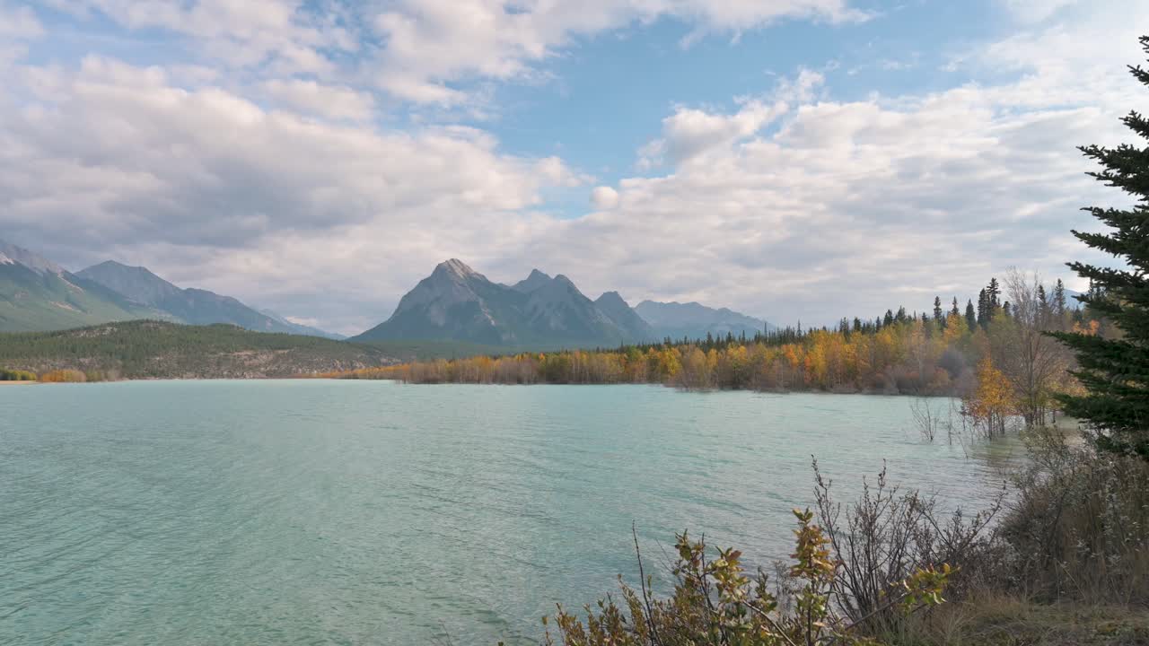 gran angular de montañas con cielos nublados y abedules amarillos en otoño