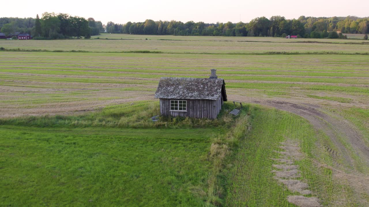 Weathered Wooden Structure Of An Old Swedish Blacksmith Workshop Standing Alone On Field. aerial shot