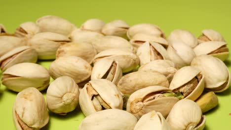 pistachios on green plate slowly rotating in detail