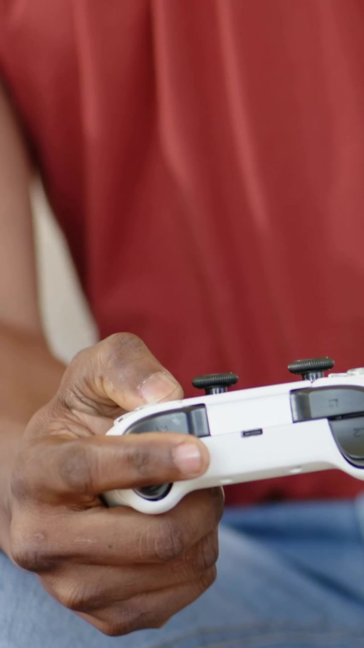 Vertical video: Child pressing white pad on sofa dad joining while UI showing thumbs during game