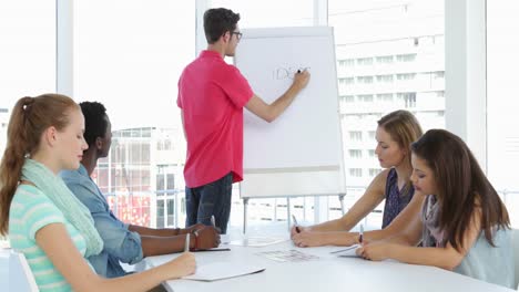 Man-giving-presentation-to-his-colleagues-at-a-meeting