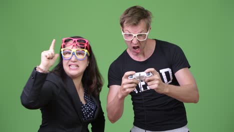 una mujer de negocios asiática madura y un joven nerd escandinavo jugando juntos.