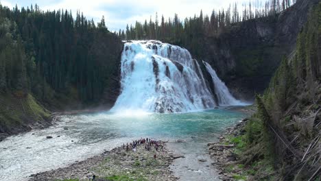 bride walking down the aisle of her wedding at the base of kinuseo waterfalls in alberta canada