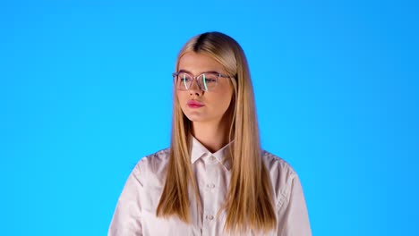 Una-Joven-Rubia-Caucásica-Con-Gafas-De-Lectura-Come-Una-Manzana-Roja,-Foto-De-Estudio